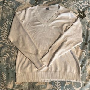 A white v-neck large sweater.